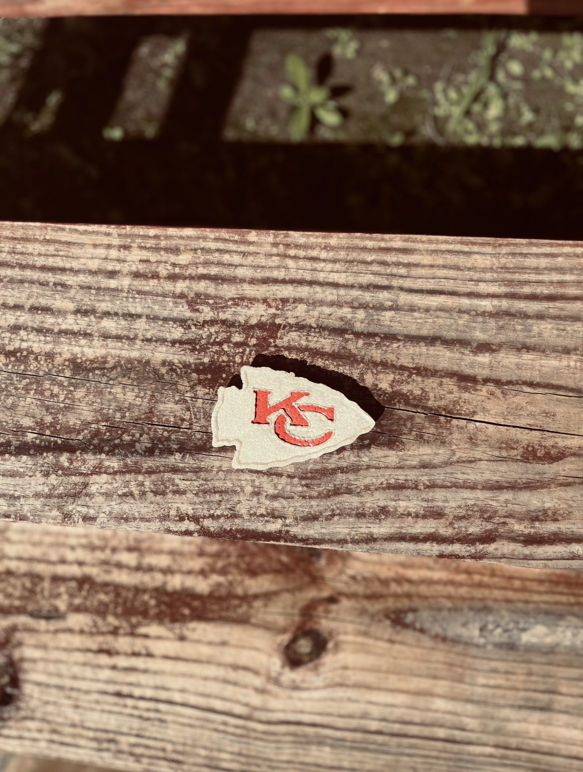 A torn heart-shaped paper with a red 'KC' logo on wooden surface.
