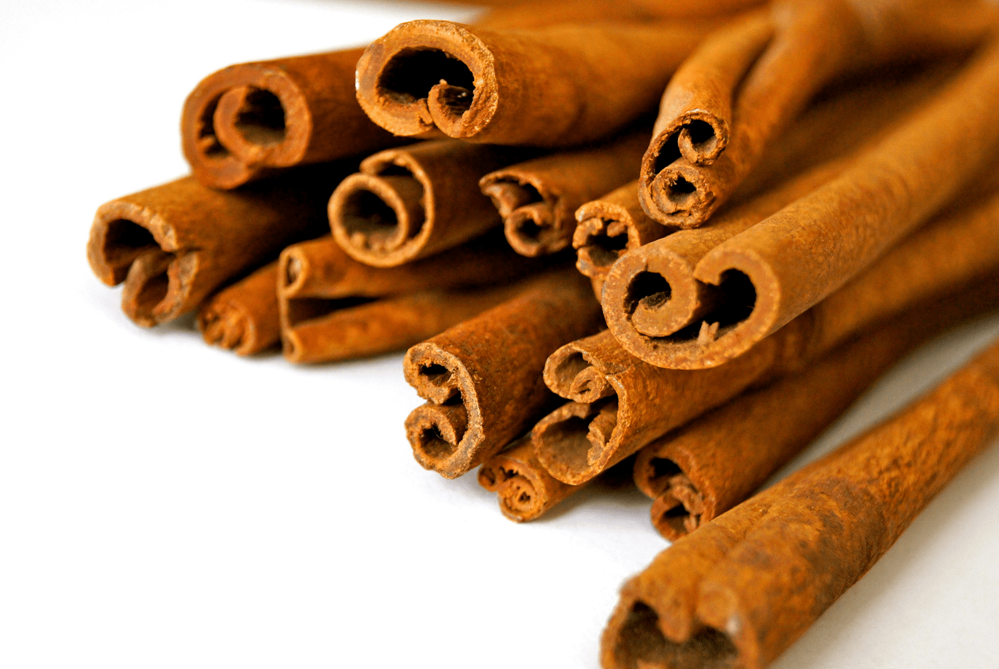 Close-up of cinnamon sticks stacked together.