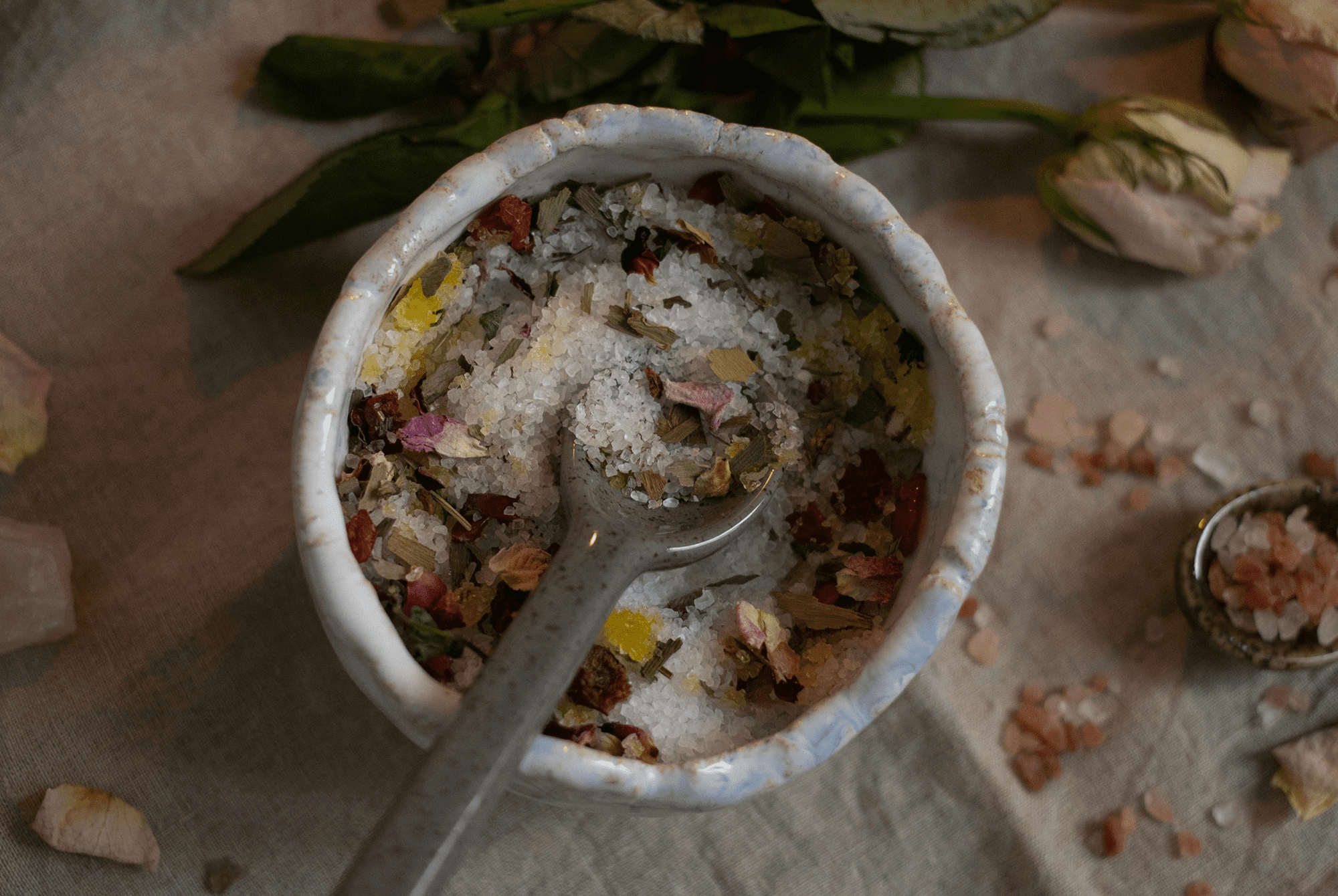 A bowl of salt mixed with various dried herbs and spices.
